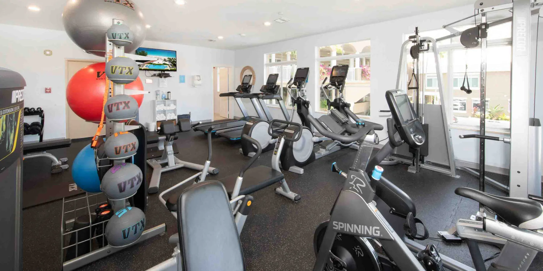 Una sala de ejercicio con bicicletas estáticas, cintas de correr y equipo de pesas.