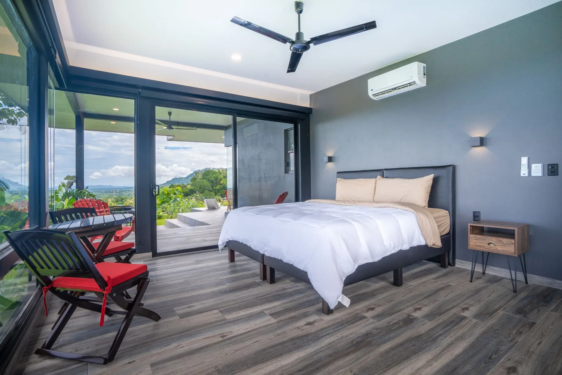 A bedroom with a large bed beside glass doors opening onto a patio.