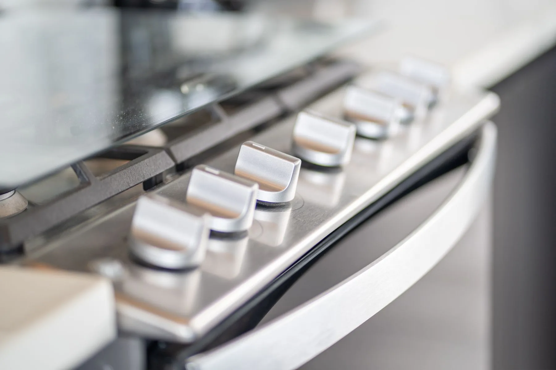 Close-up of a stovetop with a row of control knobs.