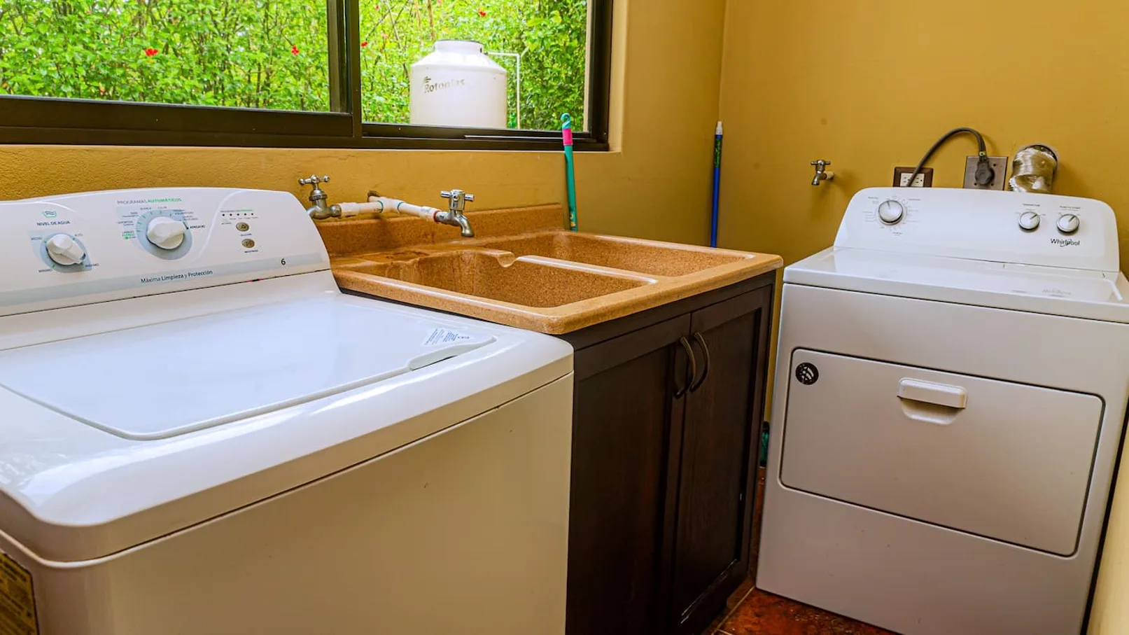 A laundry room with a washing machine, dryer, and utility sink.