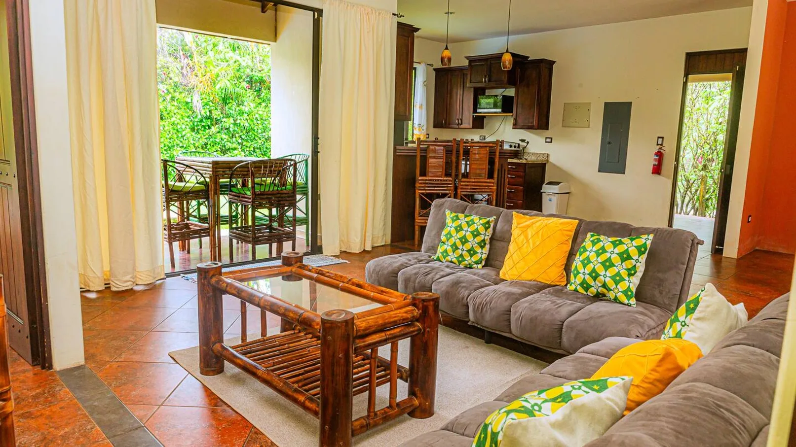 A living room with seating, a wooden coffee table, and an open view to a balcony.