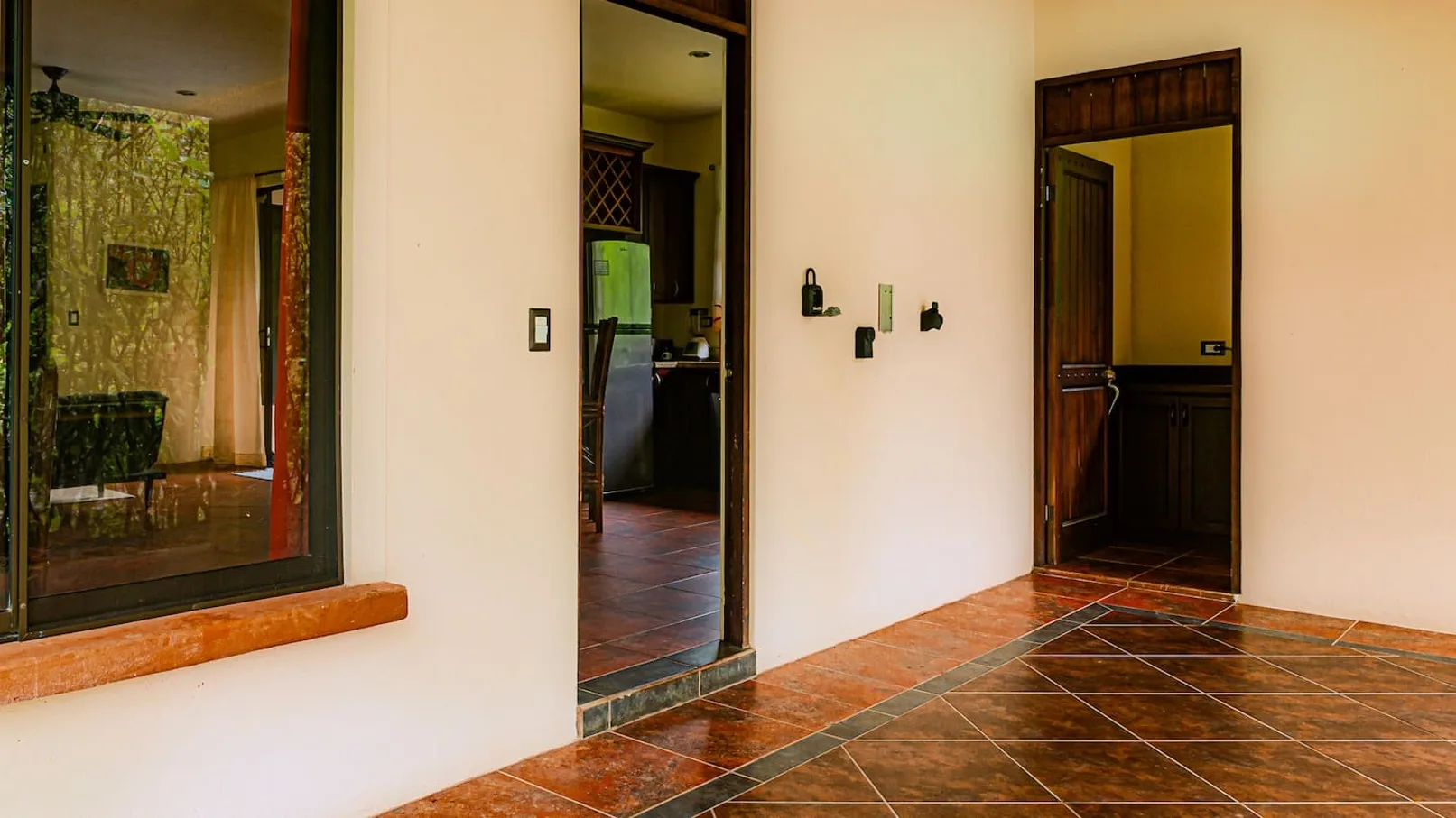 An interior hallway with tiled flooring and open doorways.