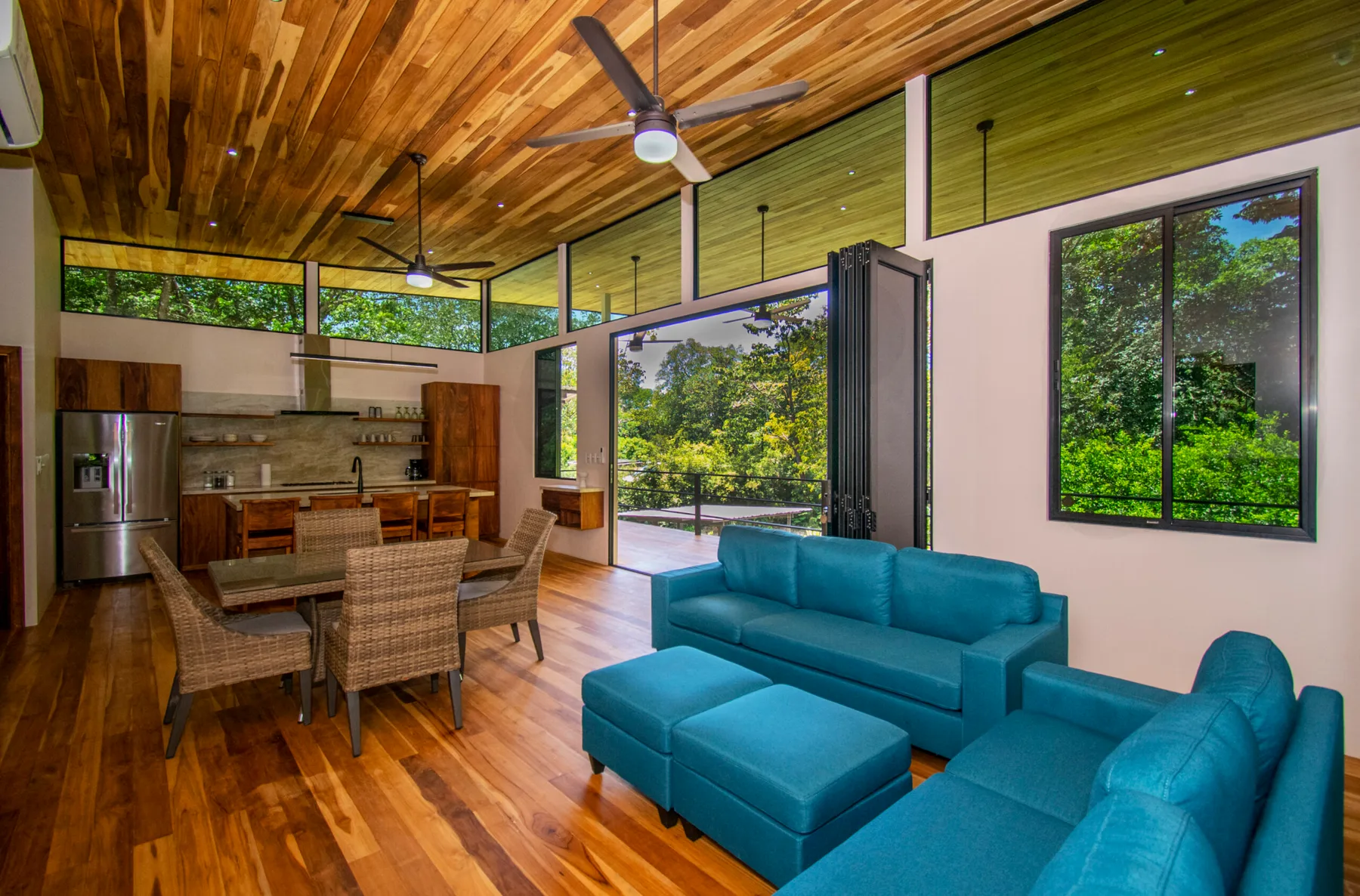 An open-plan living and dining area with blue seating and a kitchen.