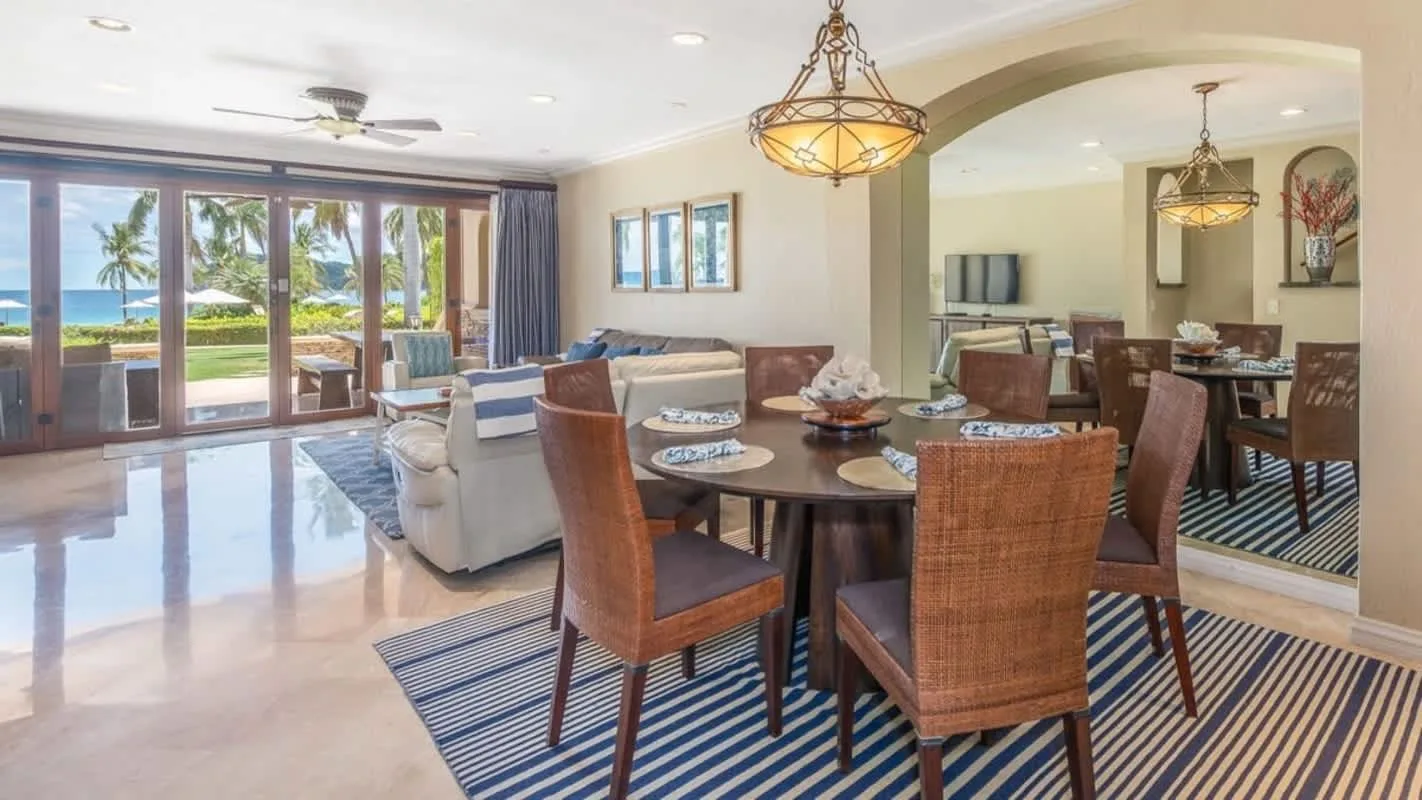 An open living and dining area with seating beside wide windows.