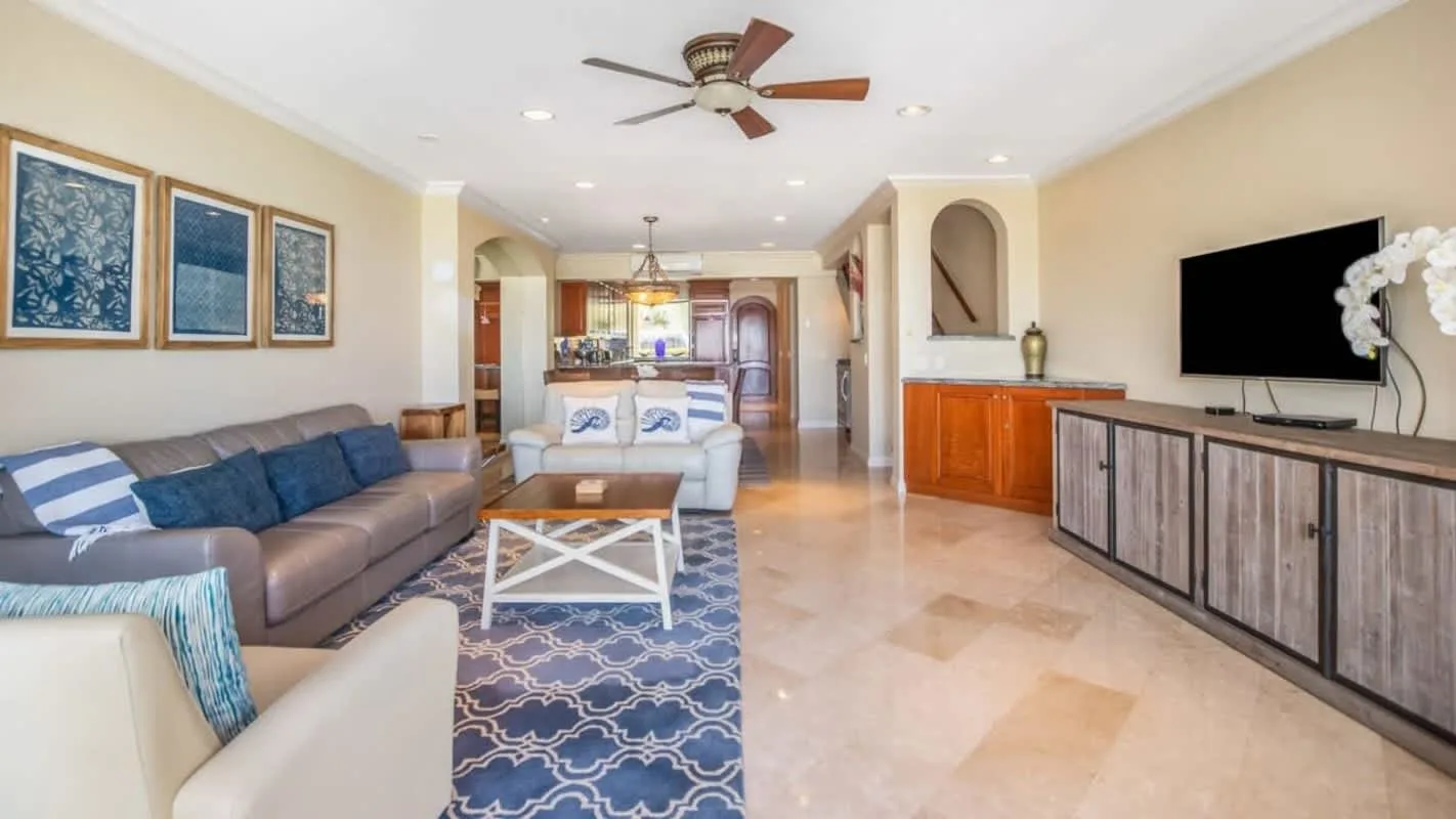 A living room with seating, a coffee table, and a wall-mounted television.