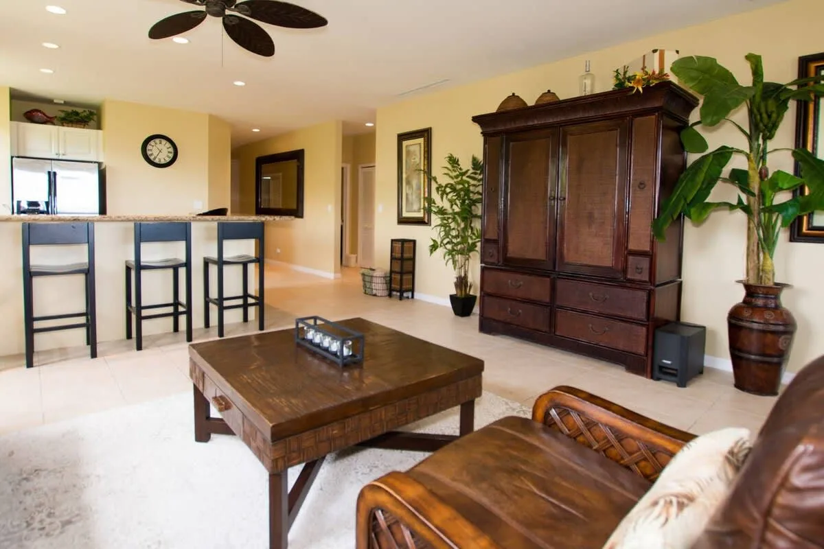 A living room with a dark wooden cabinet, coffee table, and seating.