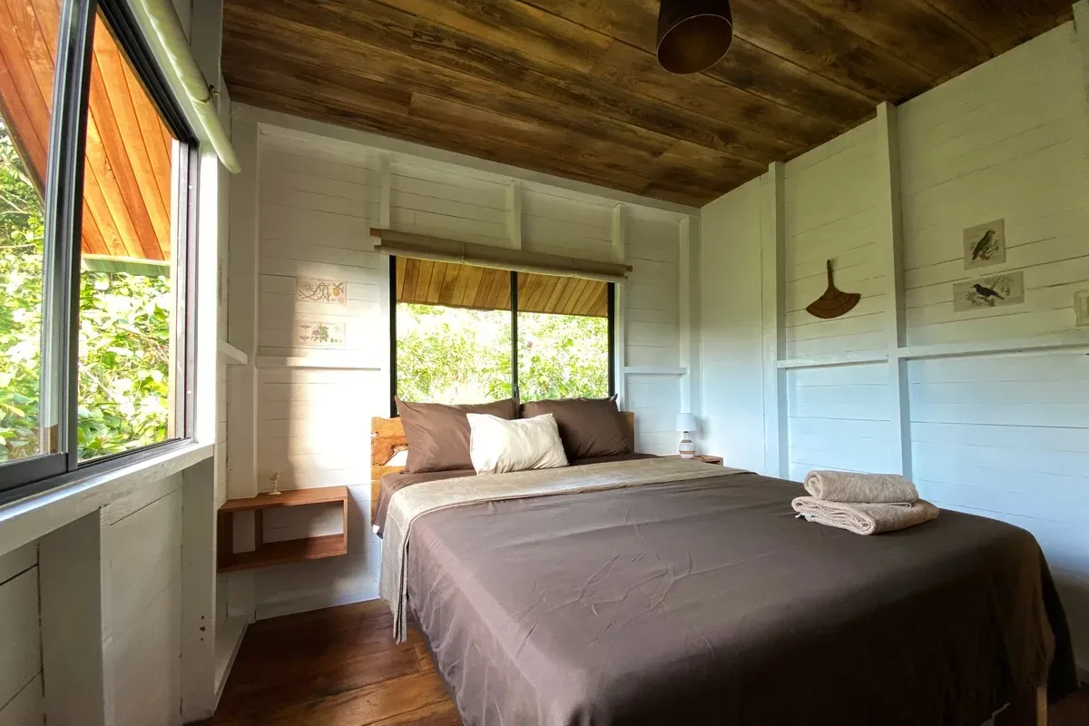 Dormitorio con cama queen junto al balcón