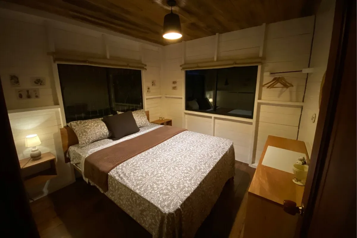 Dormitorio con cama queen de noche