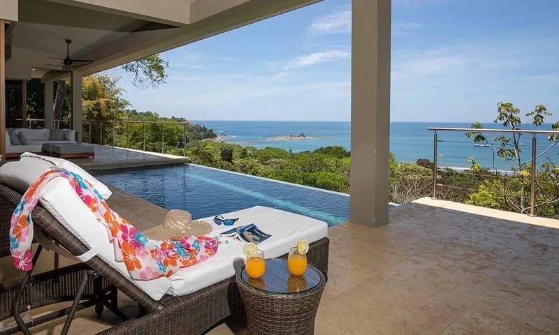 Casa Ola Vista · 2. The infinity-edge saltwater pool and covered terrace provide direct, expansive views of the Pacific Ocean and lush coastline, bathed in natural light.