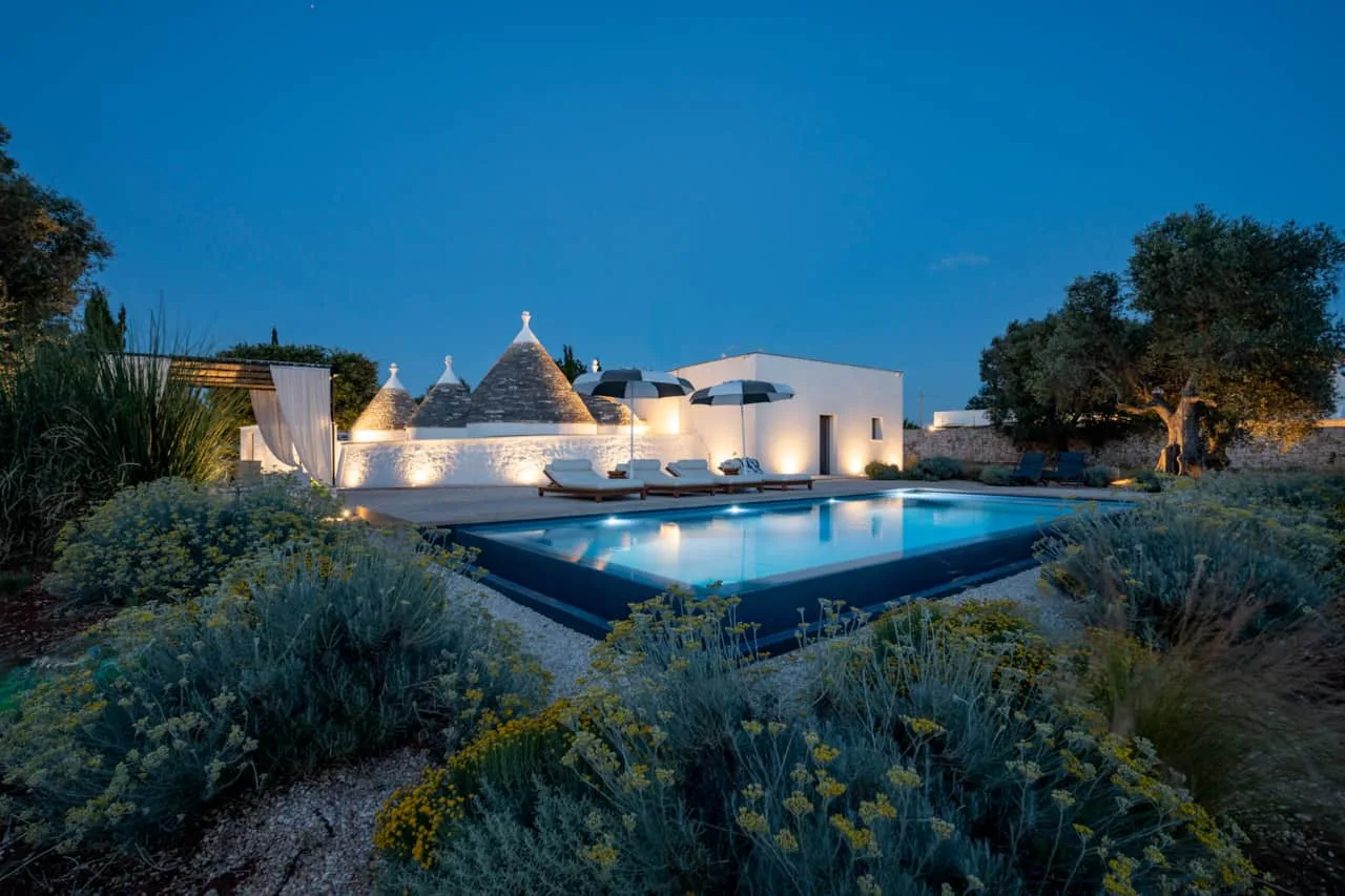 Piscina y trulli al anochecer