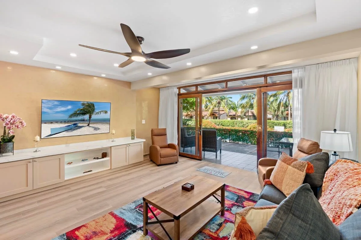 A living room with seating and sliding glass doors opening onto a garden.