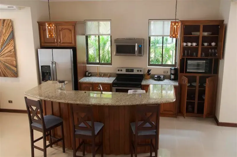A kitchen with wooden cabinets and a curved breakfast bar.