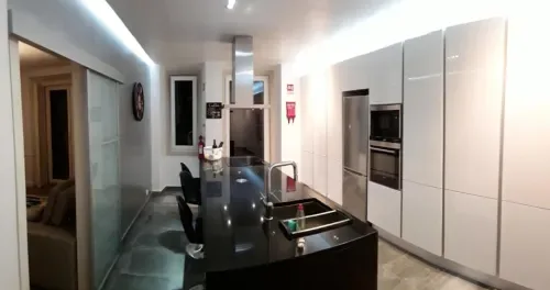 Una cocina moderna con una isla oscura y electrodomésticos empotrados.