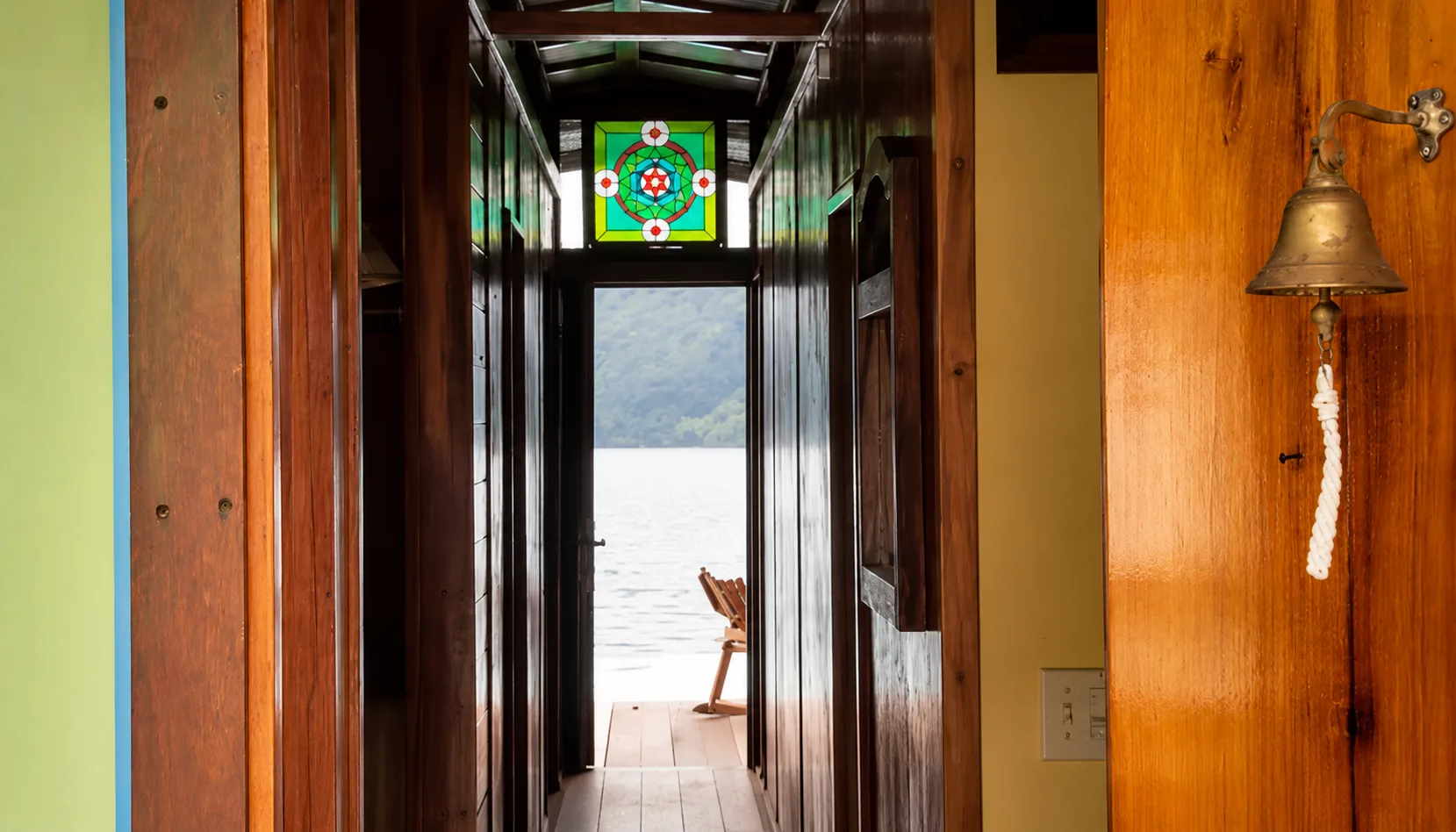 Pasillo de madera de una casa flotante de alquiler en Golfito con vista al agua