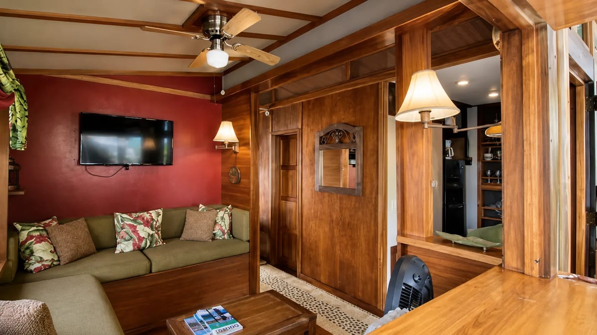 Sala de estar dentro de una casa flotante en alquiler en Golfito con paredes de madera.