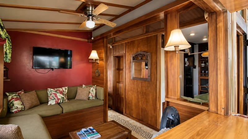 Sala de estar dentro de una casa flotante en alquiler en Golfito con paredes de madera.