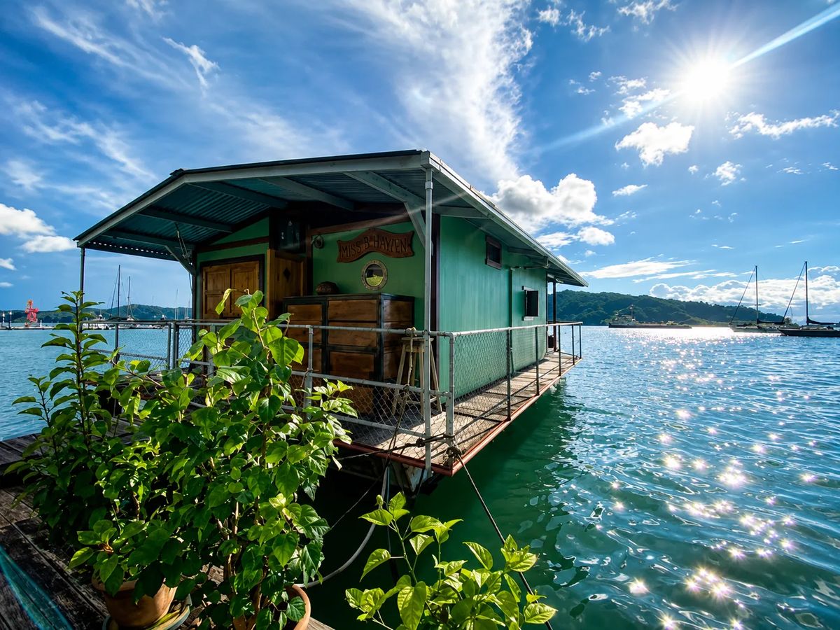Casa flotante Magic Carpet en alquiler en Golfito sobre aguas soleadas.