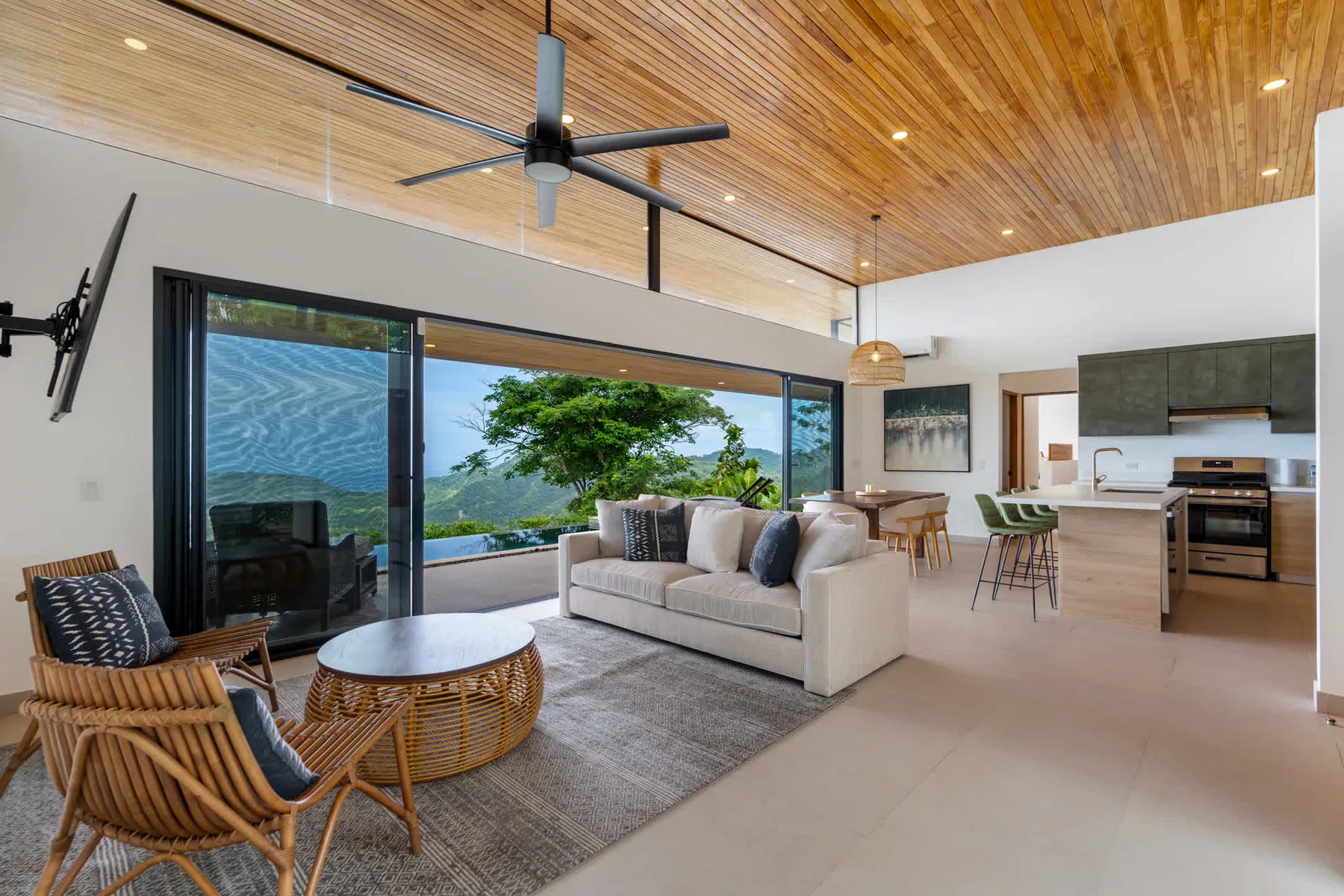 A bright open-plan living room with a seating area beside the kitchen.