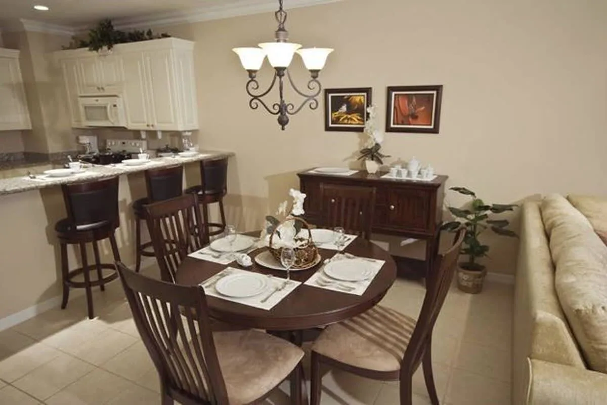 A dining area with a set table beside an open kitchen.