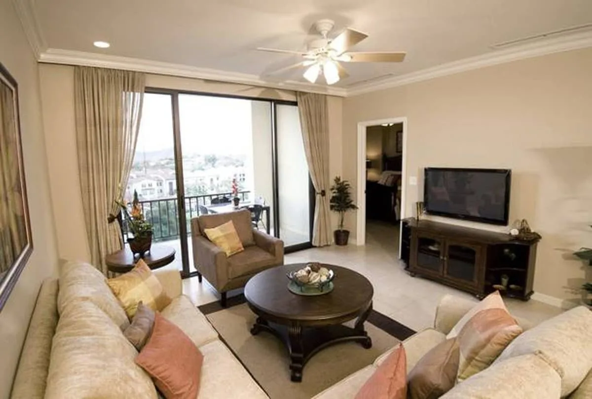 A living room with seating arranged around a coffee table beside large glass doors.
