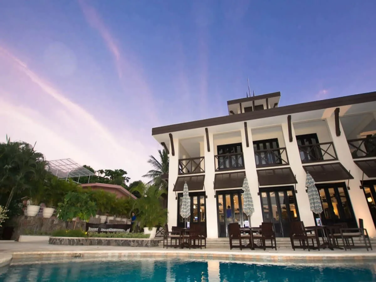 A poolside view of a multi-story building with outdoor seating.