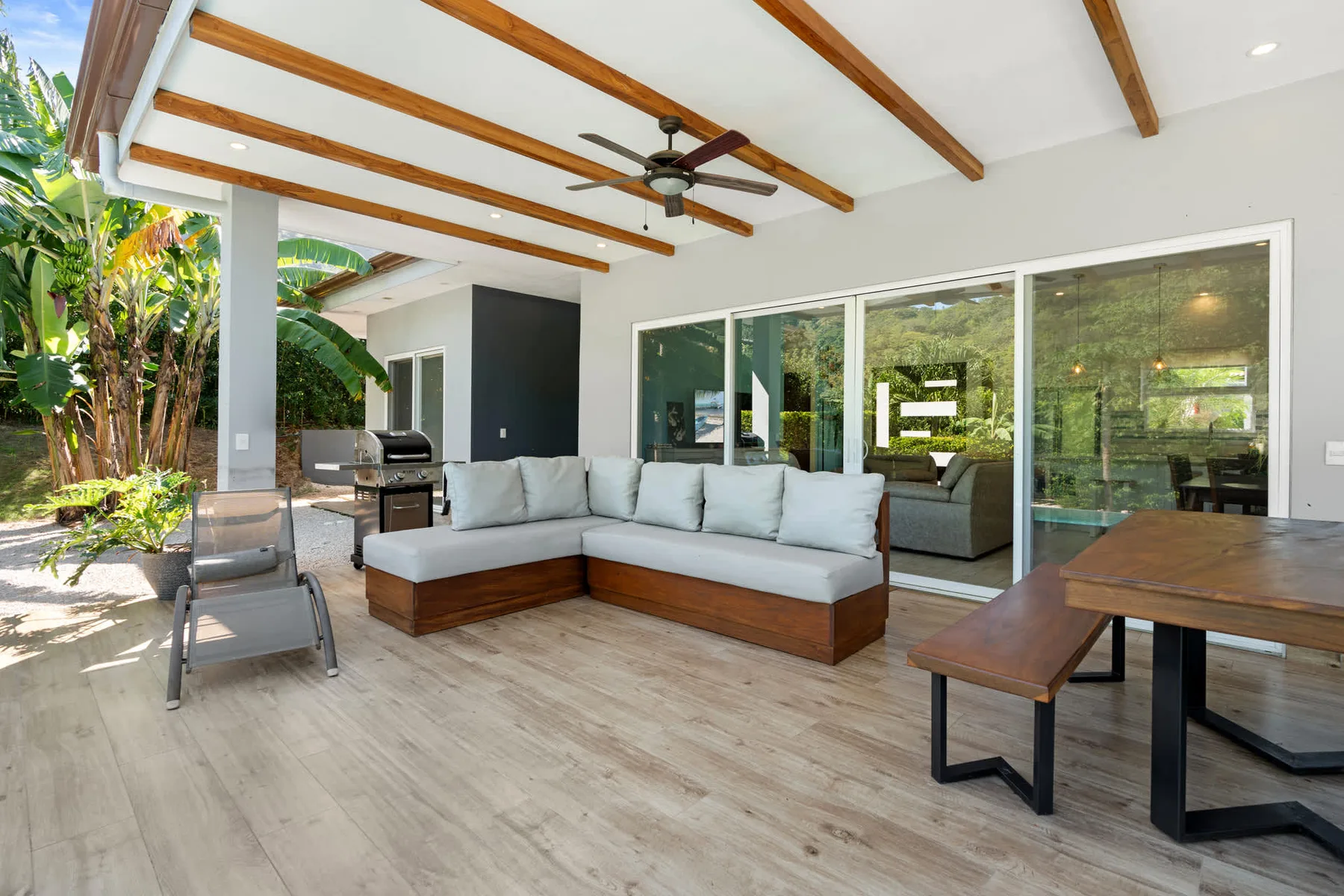 A covered patio with sectional seating and sliding glass doors.