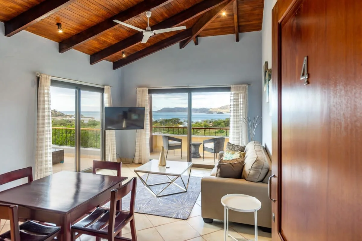 A living room with seating and large windows overlooking the landscape.