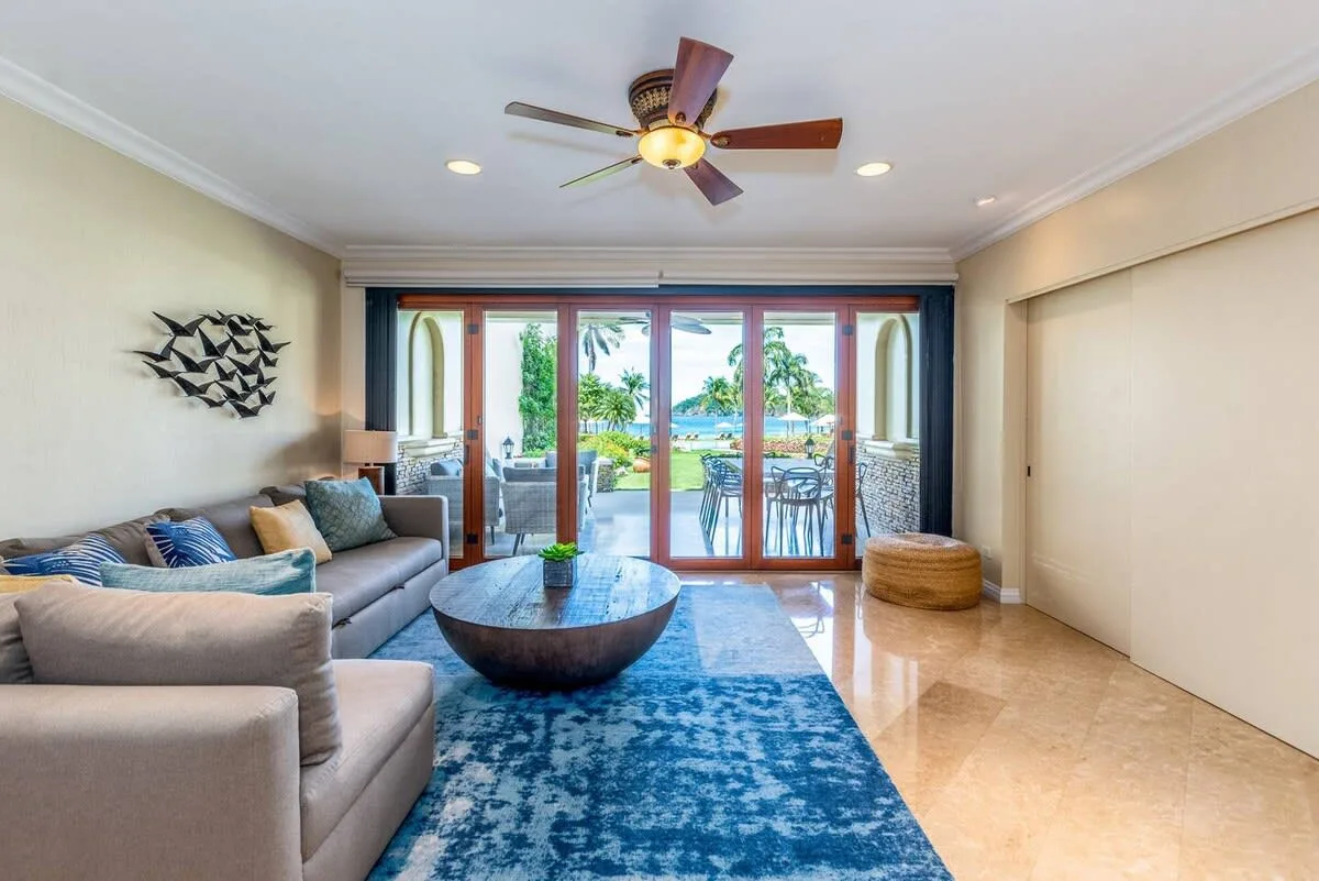 A living room with seating and glass doors opening onto a balcony.