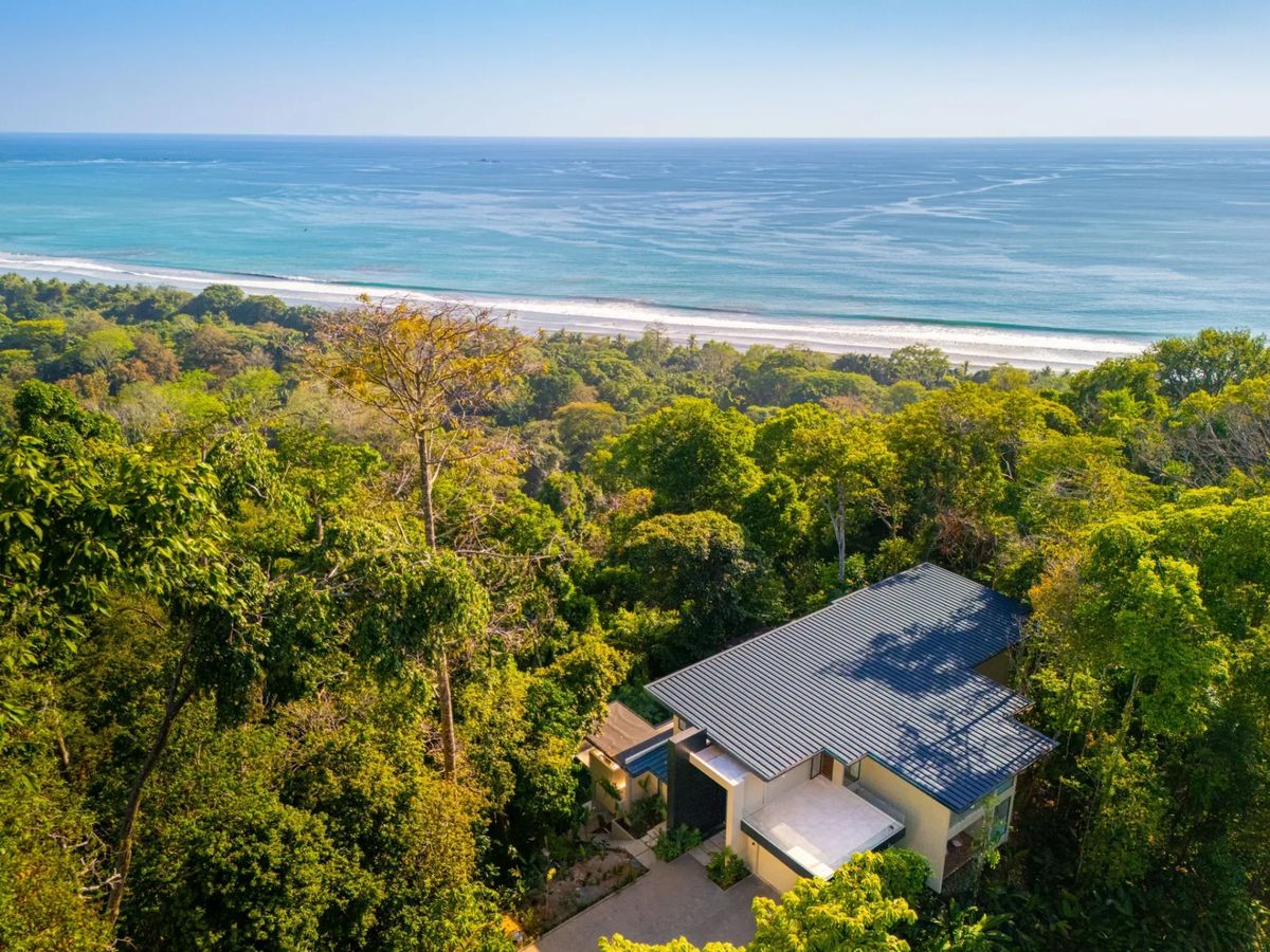 Colíbri Sur · 5. An aerial perspective reveals a modern villa nestled within a rich tropical forest, offering expansive views of the Pacific Ocean and the adjacent coastline.