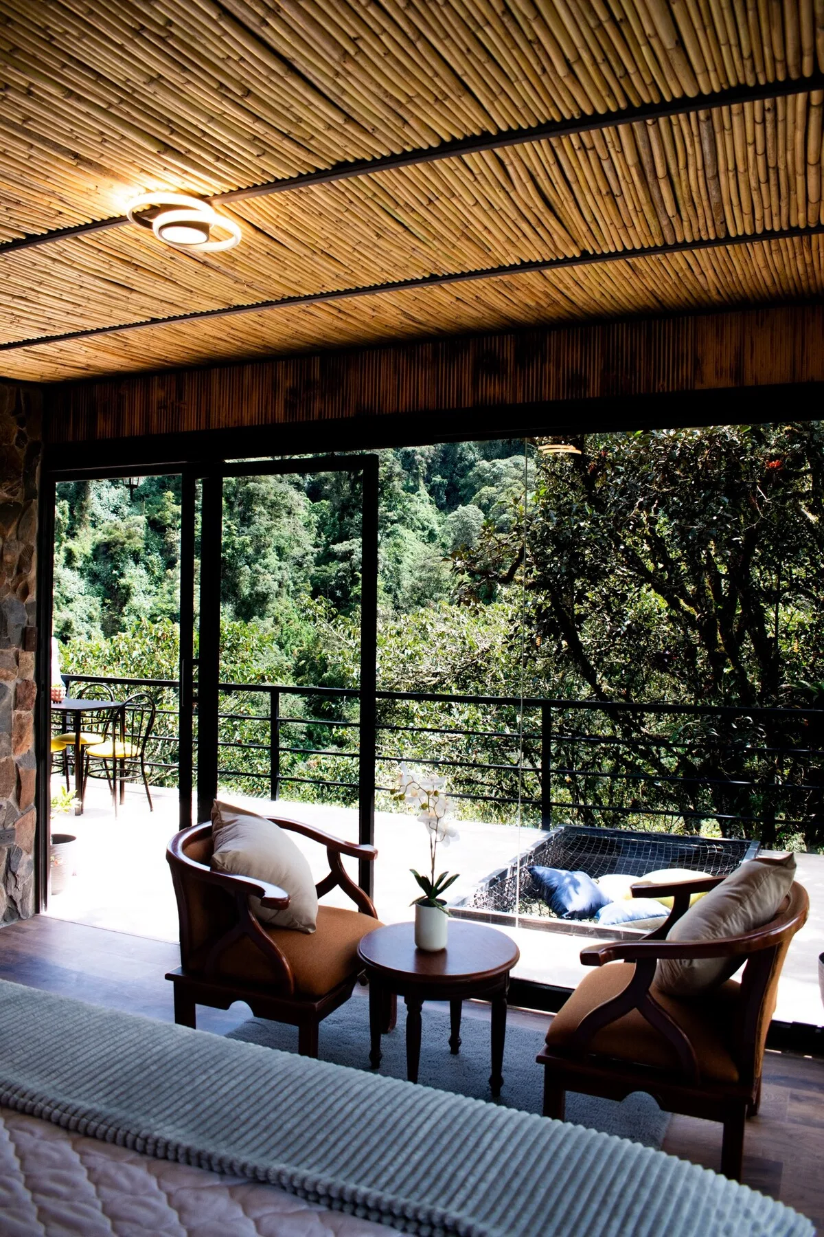 A living room opens onto a patio, with seating beside large windows.