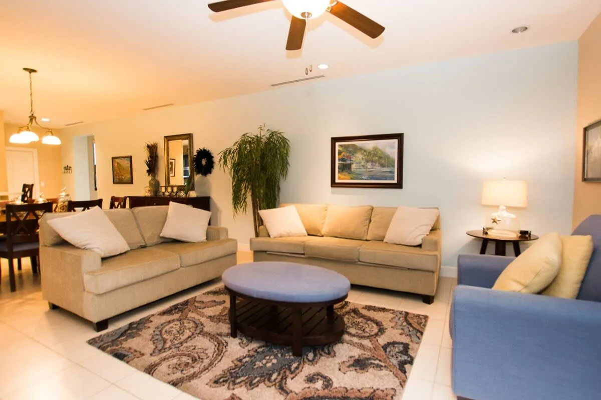 A living room with seating arranged around a coffee table on a patterned rug.