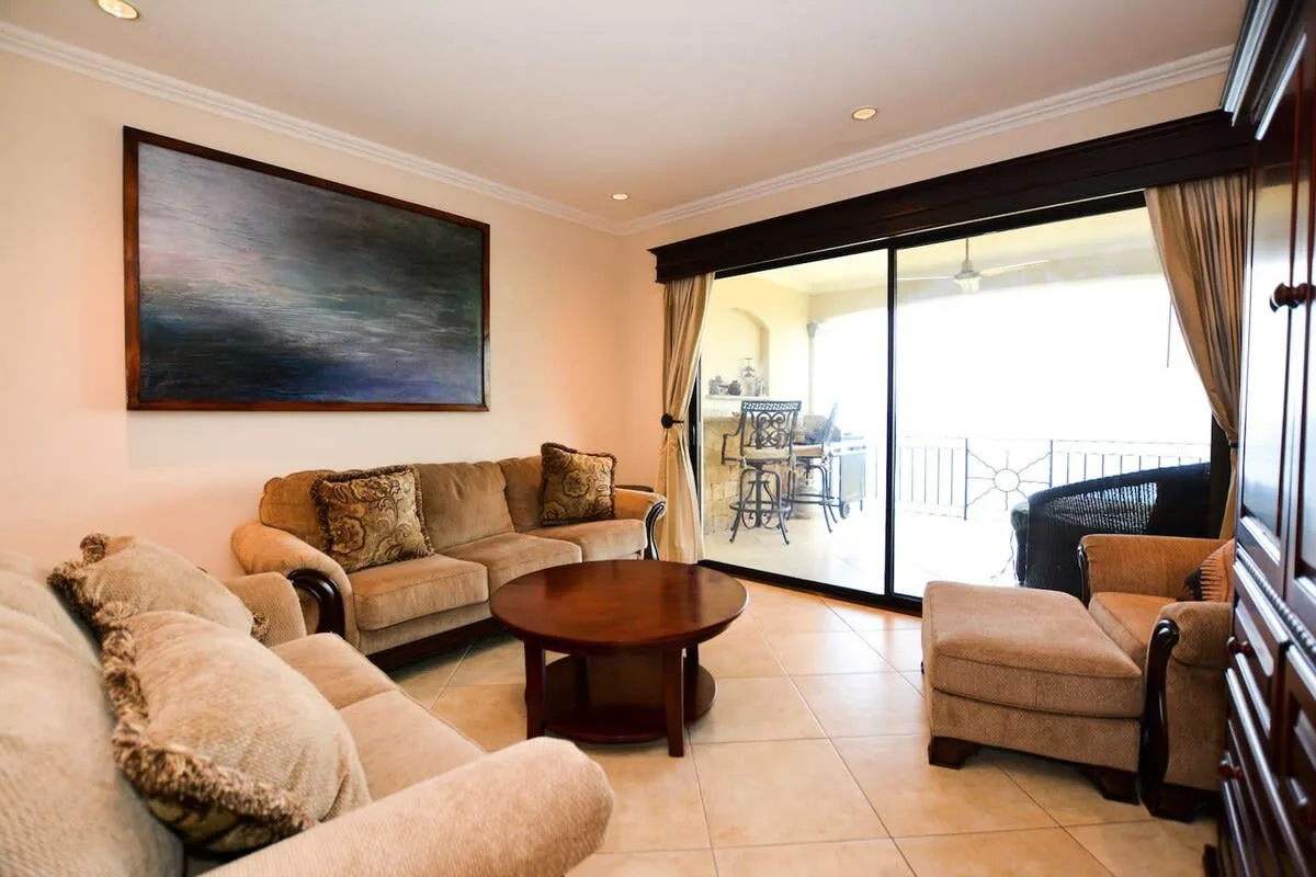A living room with seating and a coffee table beside sliding glass doors.