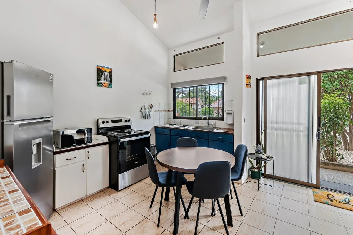 A bright kitchen and dining area with a table beside the cooking counter.