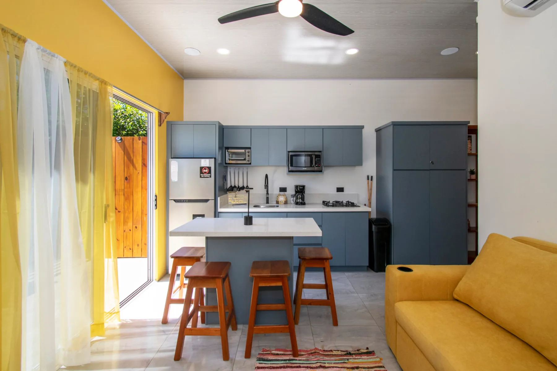 An open kitchen and living area with a counter and yellow seating.