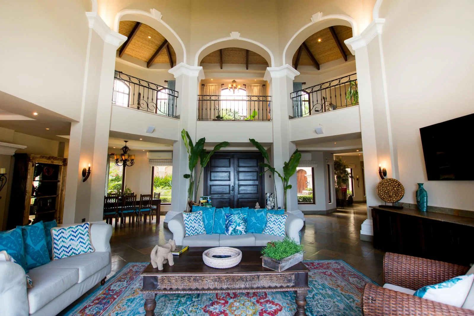 A spacious living room with seating, a coffee table, and a tall arched ceiling.