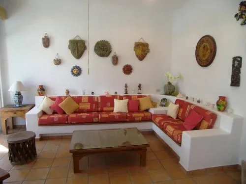 A living room with an L-shaped seating area, decorative wall hangings, and a coffee table.