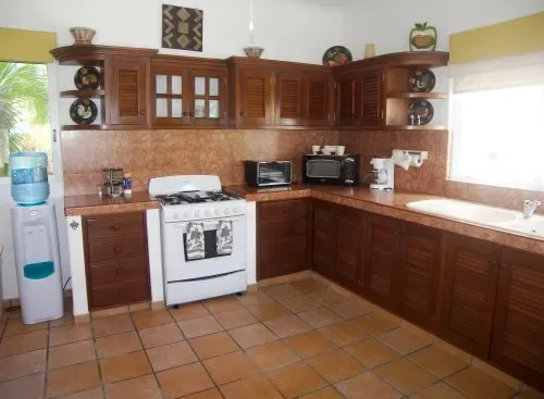 A kitchen with dark wood cabinets, a stove, and a countertop.