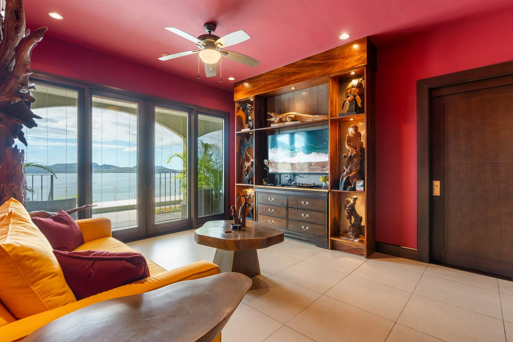 A colorful living room with seating beside large windows overlooking the water.