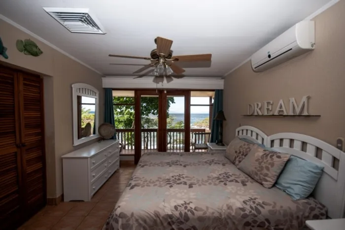 A bedroom with a large bed and glass doors opening onto a balcony.