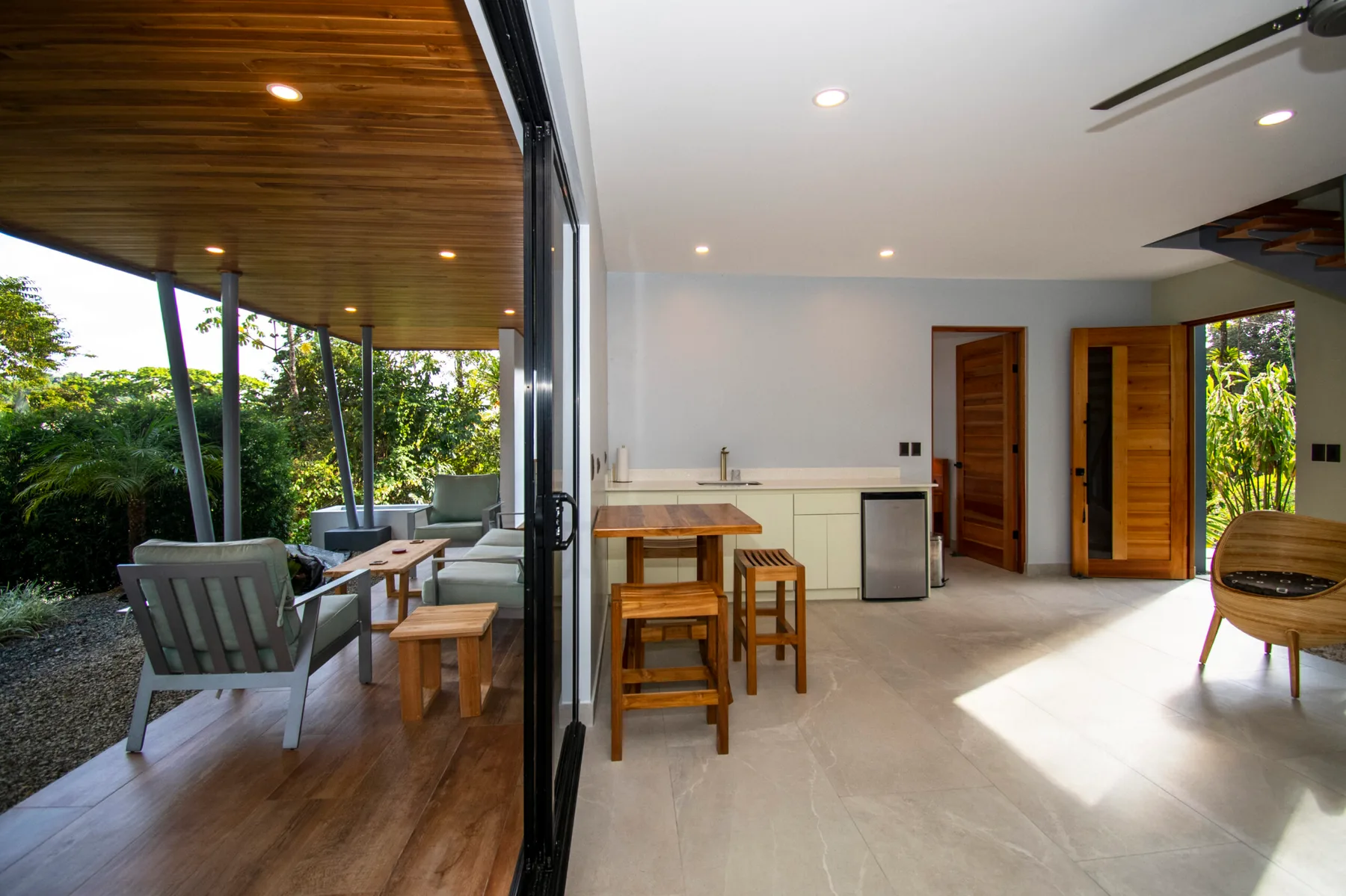 An open kitchen and dining area connects to a covered patio with seating.