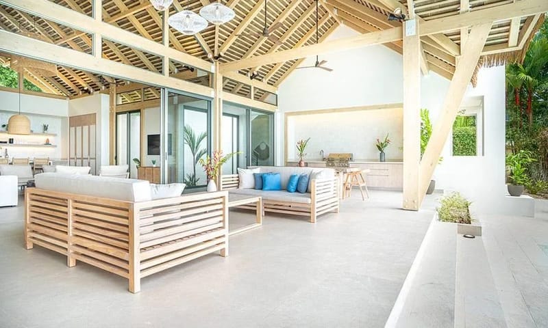 Casa Frenchie & Guest House · 31. The expansive outdoor living space beneath a vaulted wooden ceiling features comfortable seating, an outdoor kitchen, and large glass doors that open to integrate with the surrounding jungle.