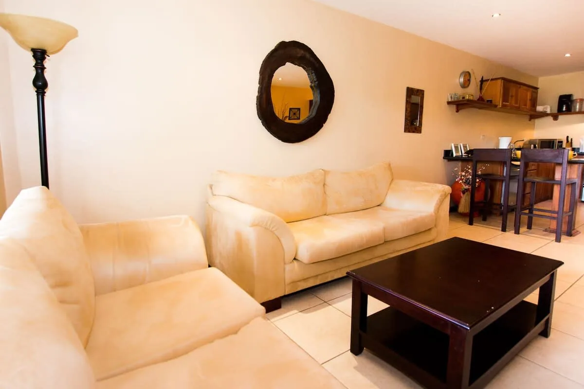 A living room with light-colored seating and a dark coffee table.