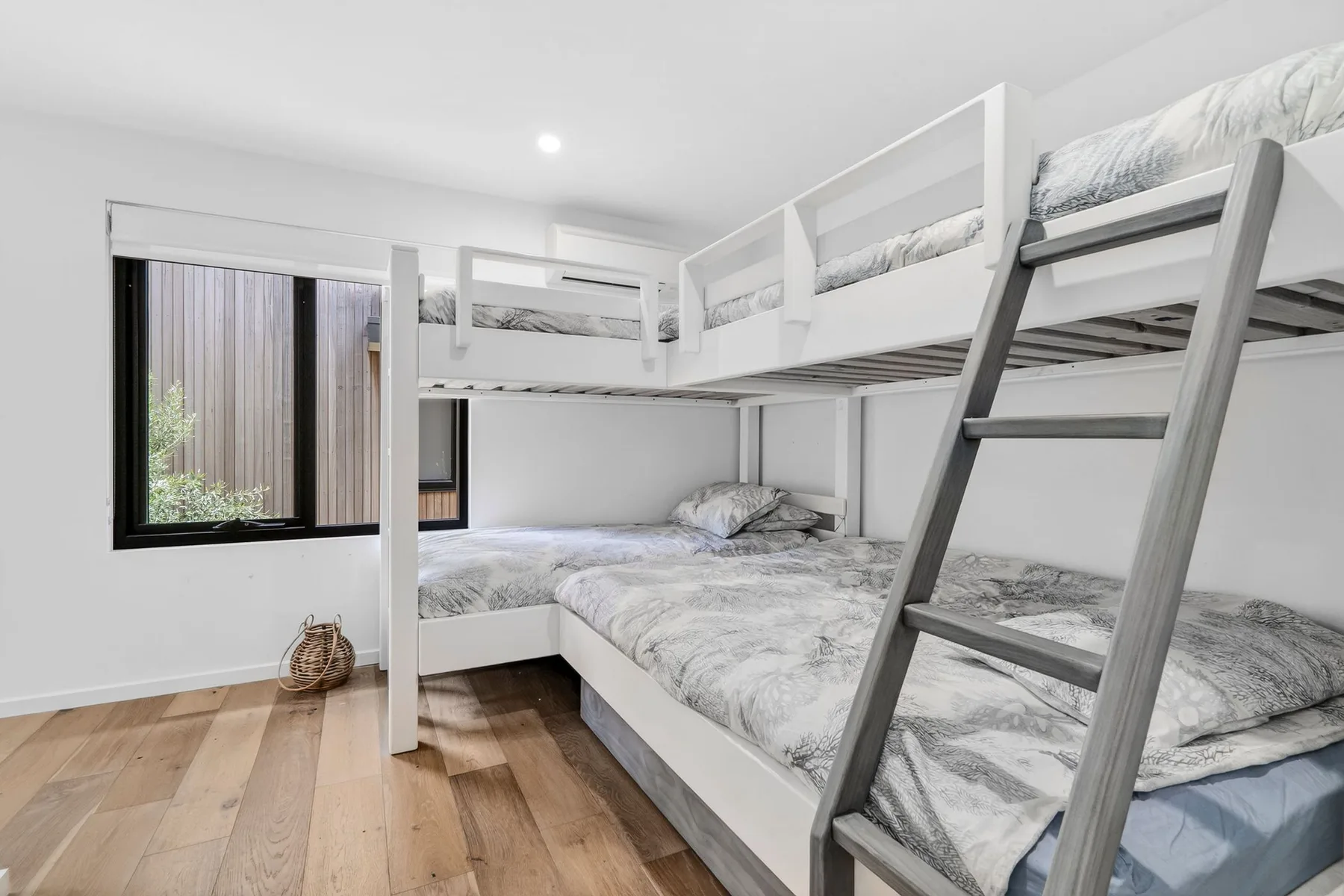 Un dormitorio con literas y ventanas grandes.