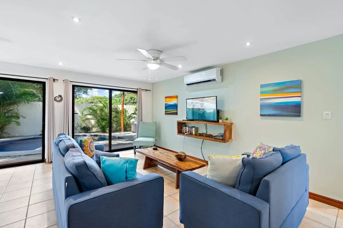 Living room with blue seating, a coffee table, and sliding glass doors.