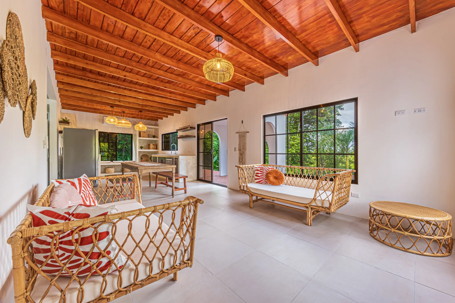 A bright living room with woven seating and an exposed wooden ceiling.