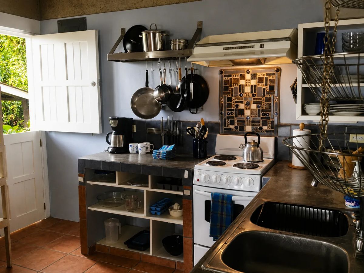 Cocina en un alojamiento vacacional en Golfito con una cocina blanca.