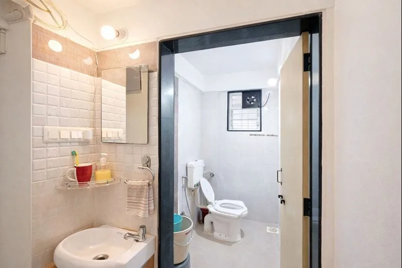 Un baño con lavabo y una puerta abierta que da a un inodoro.