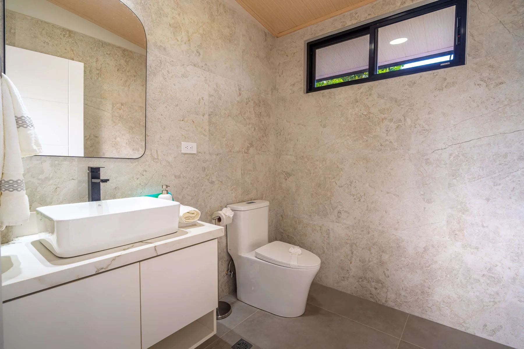 Un baño con lavabo, espejo e inodoro.