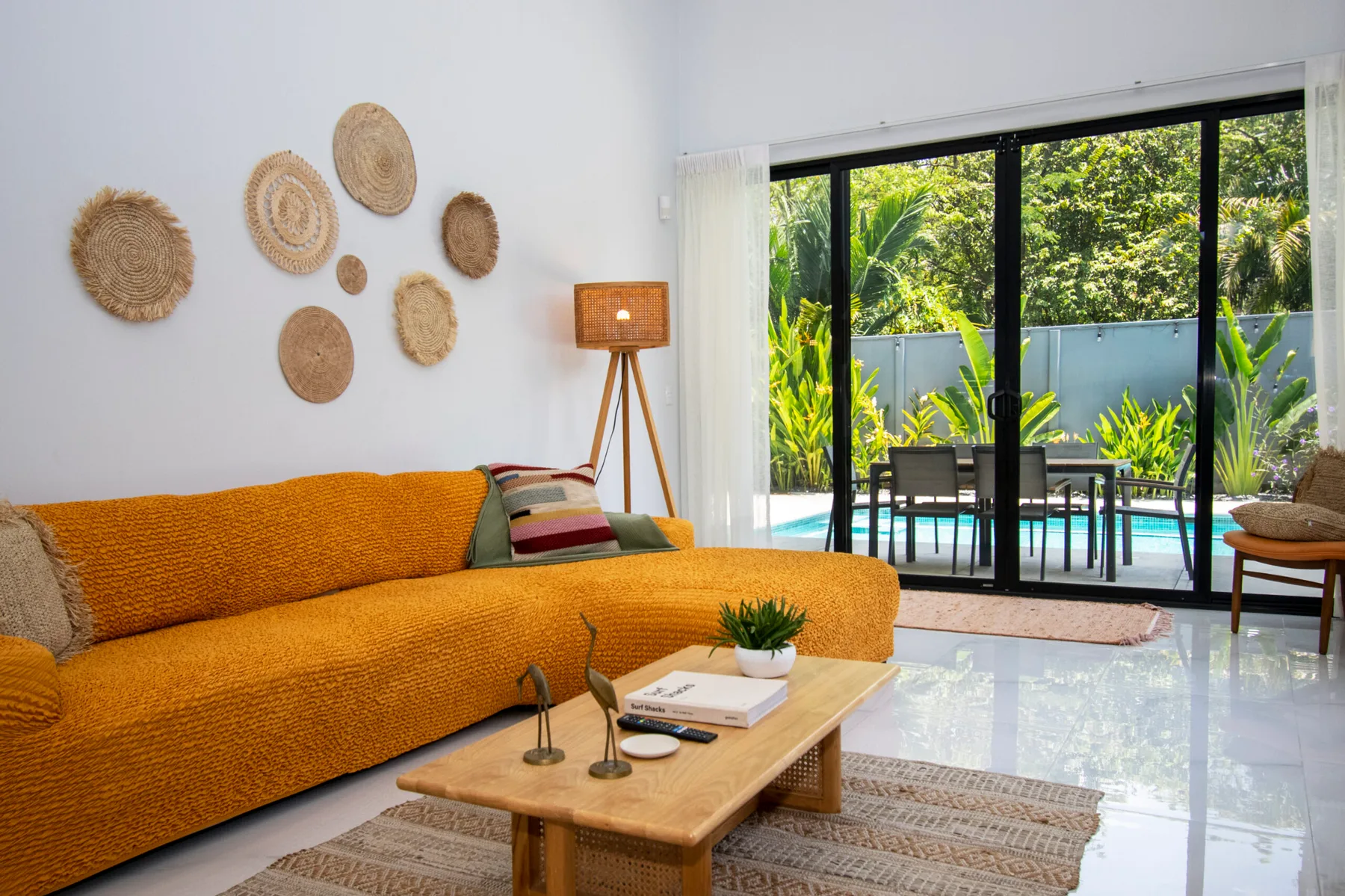 A bright living room opens onto a patio with a table and chairs.