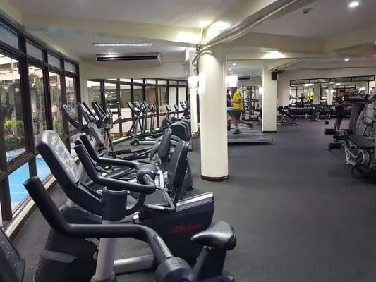 Un gimnasio con filas de bicicletas estáticas y otros equipos de ejercicio.